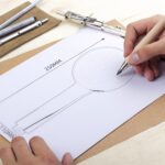 Someone is creating a technical drawing (250mm x 110mm) with a pencil, surrounded by drawing tools and pens.