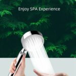 Close-up of a handheld showerhead spraying water with green foliage background. Text above: "Enjoy SPA Experience.