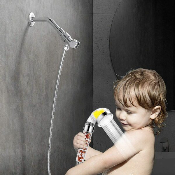 A young child showers with a detachable showerhead in a modern bathroom.