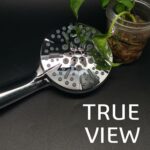 항아리 안의 작은 식물 옆에 있는 휴대용 금속 샤워기 헤드의 클로즈업, 오른쪽에 "TRUE VIEW" 표시.