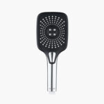 A black and silver rectangular showerhead with many small water holes and a central cluster of four larger nozzles.