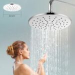 A woman with a bun enjoys a shower under a 22.5 cm rain-style showerhead with water flowing down.