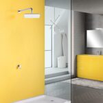 Modern bathroom with yellow walls, glass shower, wall-mounted showerhead, yellow vanity, and large mirror.