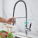 Someone washing vegetables in a sink with a modern, high-arc spring faucet and 360-degree rotating spout.