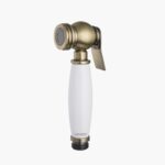 A brass and white handheld bidet sprayer with a lever handle for toilet hygiene.