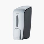 Un elegante dispenser di sapone touch-free grigio e bianco montato a parete su sfondo bianco.