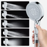 Hand holding a shower head with multiple spray modes in five rows, displaying various water flow patterns and intensities.