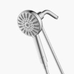 Close-up of a silver handheld shower head with a flexible hose and multiple nozzles.