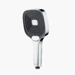 사각형 면과 작은 노즐이 달린 크롬과 검은색 핸드헬드 샤워 헤드 물 절약기가 단순한 흰색 배경에 놓여 있습니다.