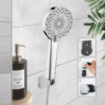 A silver handheld showerhead is mounted on a bathroom wall next to a "AU LAIT" soap dispenser. Three smaller images show attachment steps.