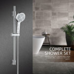 Modern bathroom: gray walls, shower set, freestanding bathtub, potted plant, stool, and towel. Text: "COMPLETE SHOWER SET.