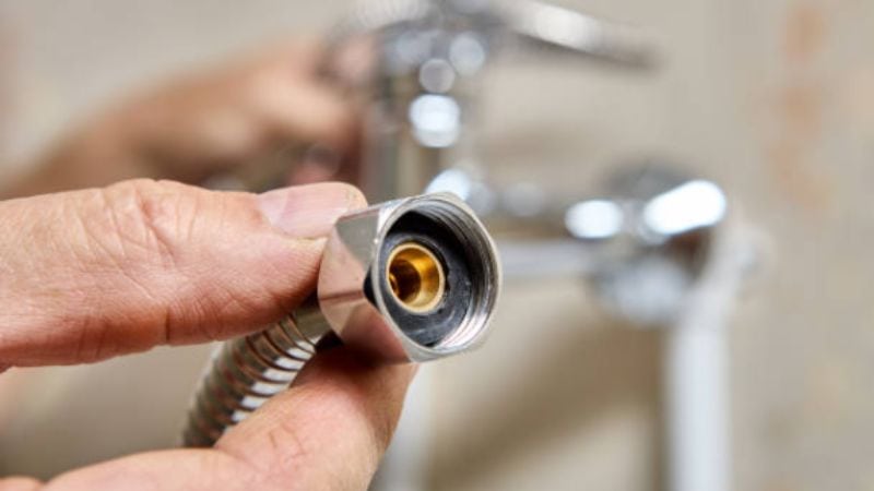 Flexible metal water supply hose with brass connector for plumbing repair or installation.