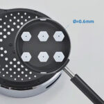 Close-up of high-pressure shower head with six hexagonal nozzles, each with a 0.6mm diameter, designed for optimal rainfall and massage modes.