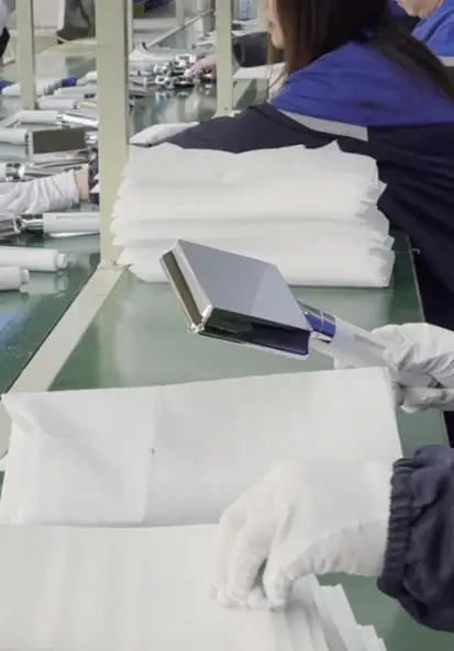 Workers in a textile factory handling fabric and materials on an assembly line at Leelongs, showcasing manufacturing and quality control.