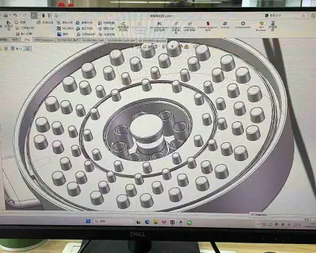 Detailed view of a circular mechanical component with multiple small protrusions and central hub, likely part of a manufacturing or engineering project.