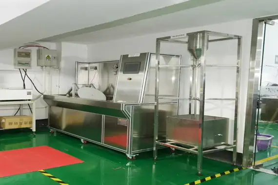 Modern stainless steel food processing machinery in a clean, well-lit facility with green flooring and safety markings.